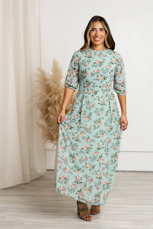 Modest floral maxi dress with sleeves featuring sage mint background and coral blooms, perfect for a romantic look.
