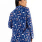 Model wearing the Woodland Night women's nightshirt long sleeve with a colorful forest print on a blue background.