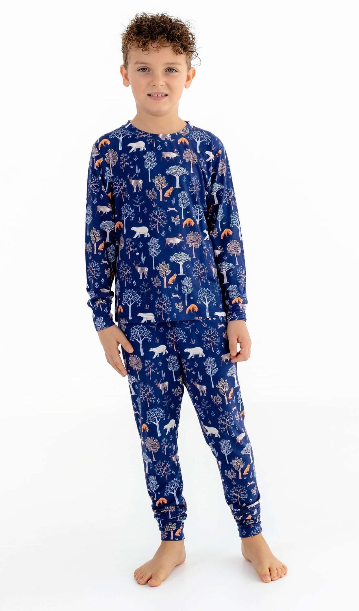 Front view of child wearing kids pajama set in Woodland Night forest print