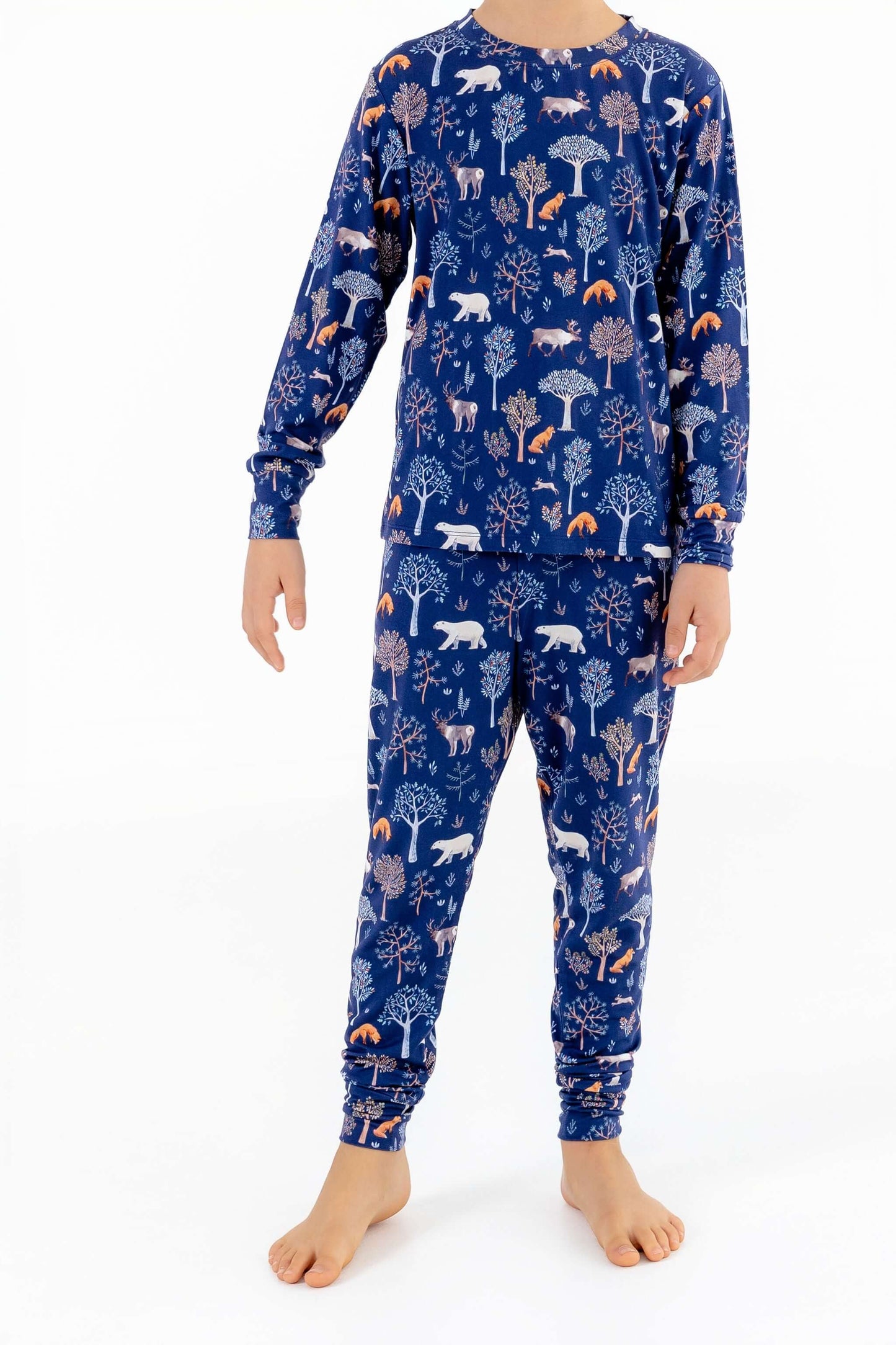 Front view of child wearing kids pajama set in Woodland Night forest print