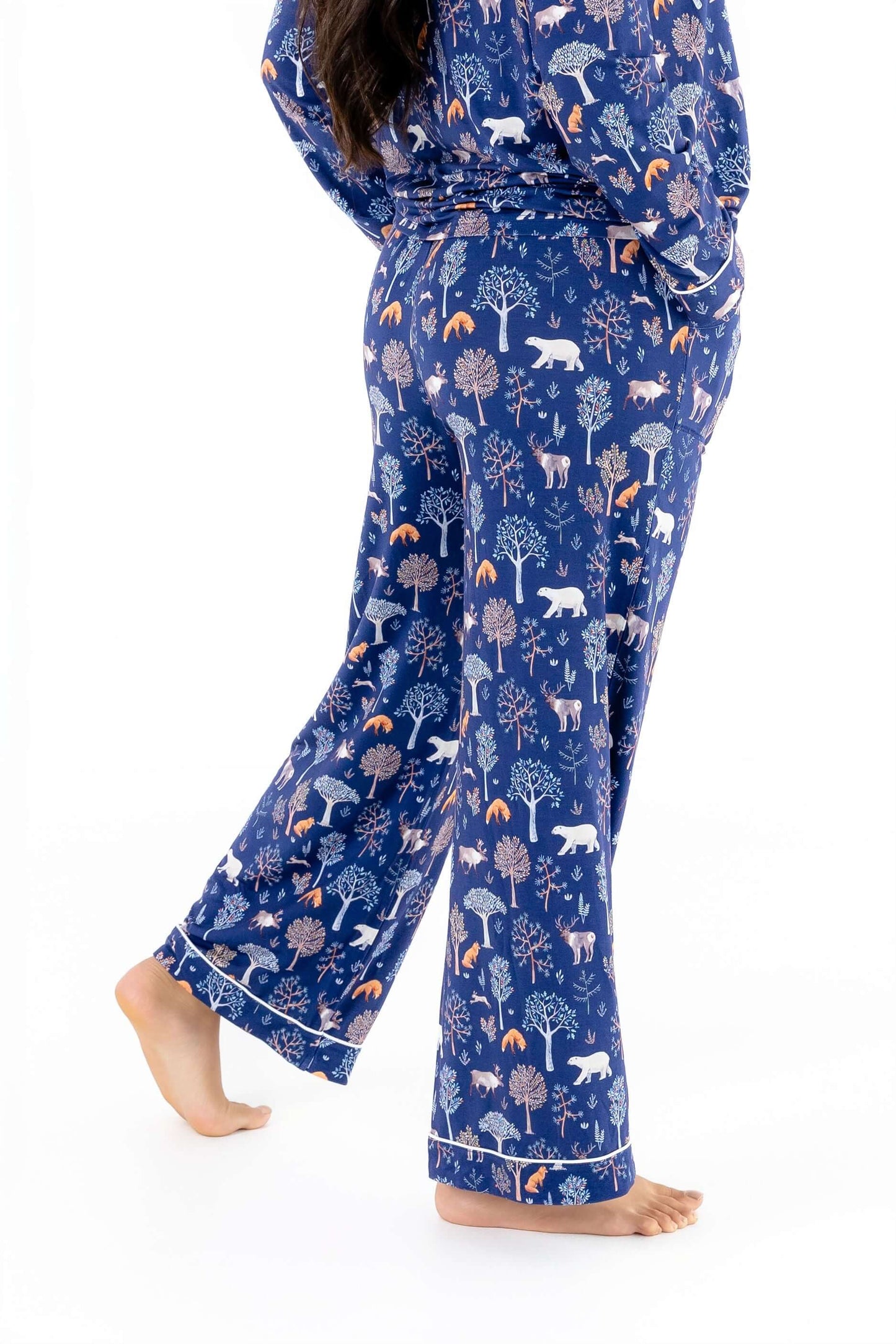 Woman wearing Women TENCEL Modal Pajama Set Woodland Midnight with forest pattern, showcasing soft, sustainable, and breathable material.