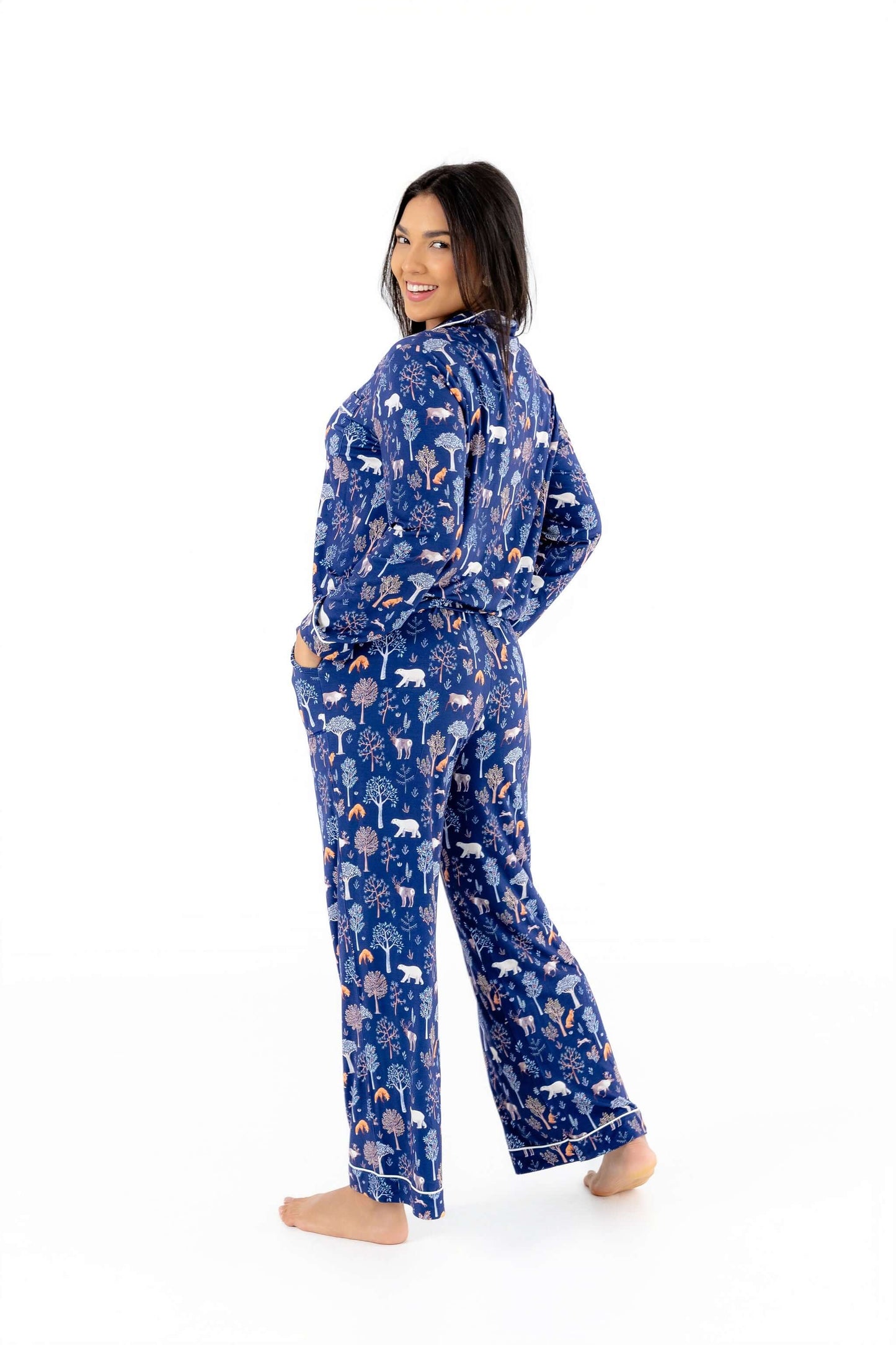 Woman wearing Women TENCEL Modal pajama set in Woodland Night print, long sleeve, standing in profile.