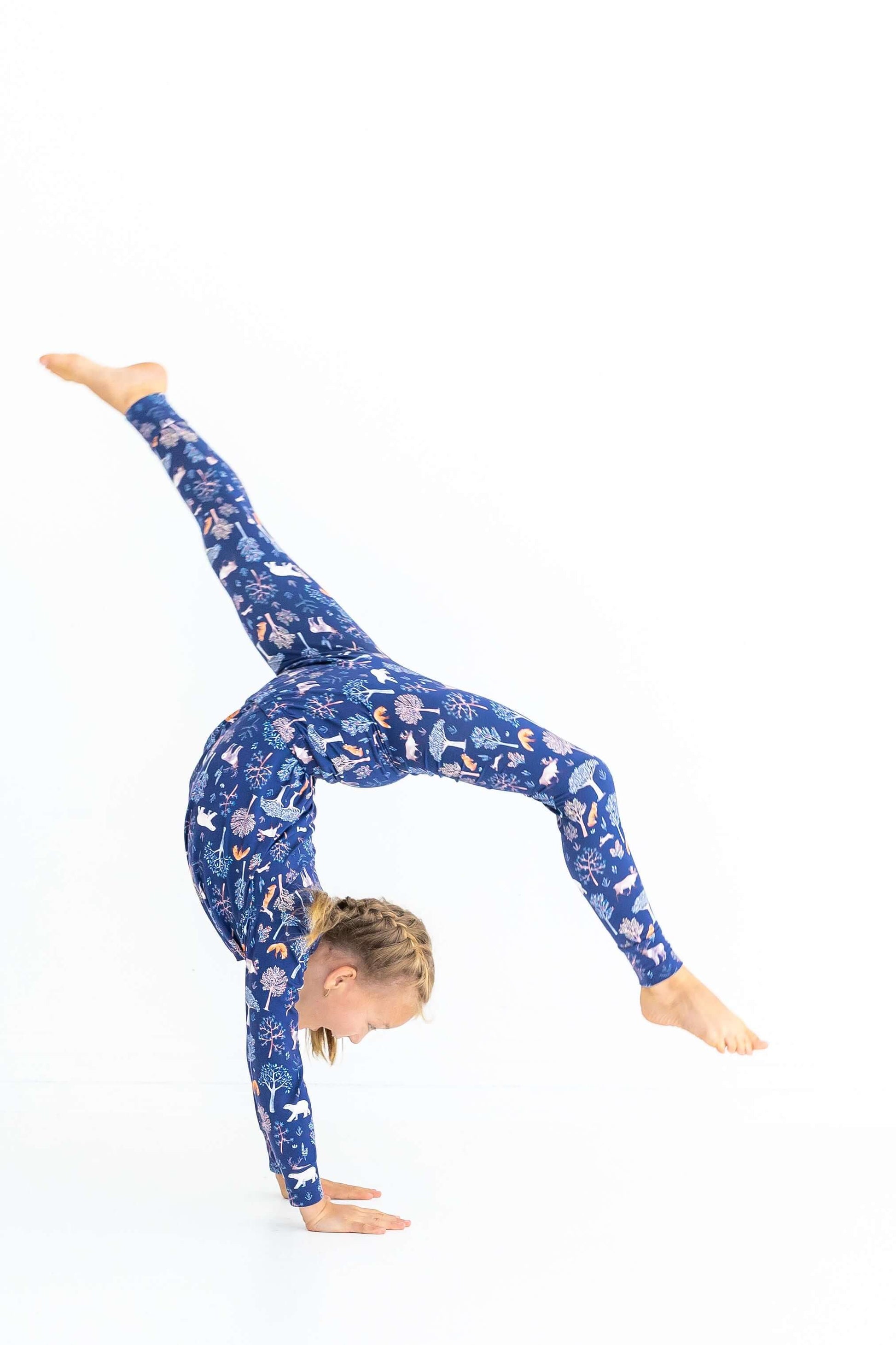 Kids pajama set made from stretchy modal shown as girl cartwheels in Woodland Night print