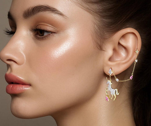 Close-up of a woman wearing a unicorn-themed earring against a neutral background